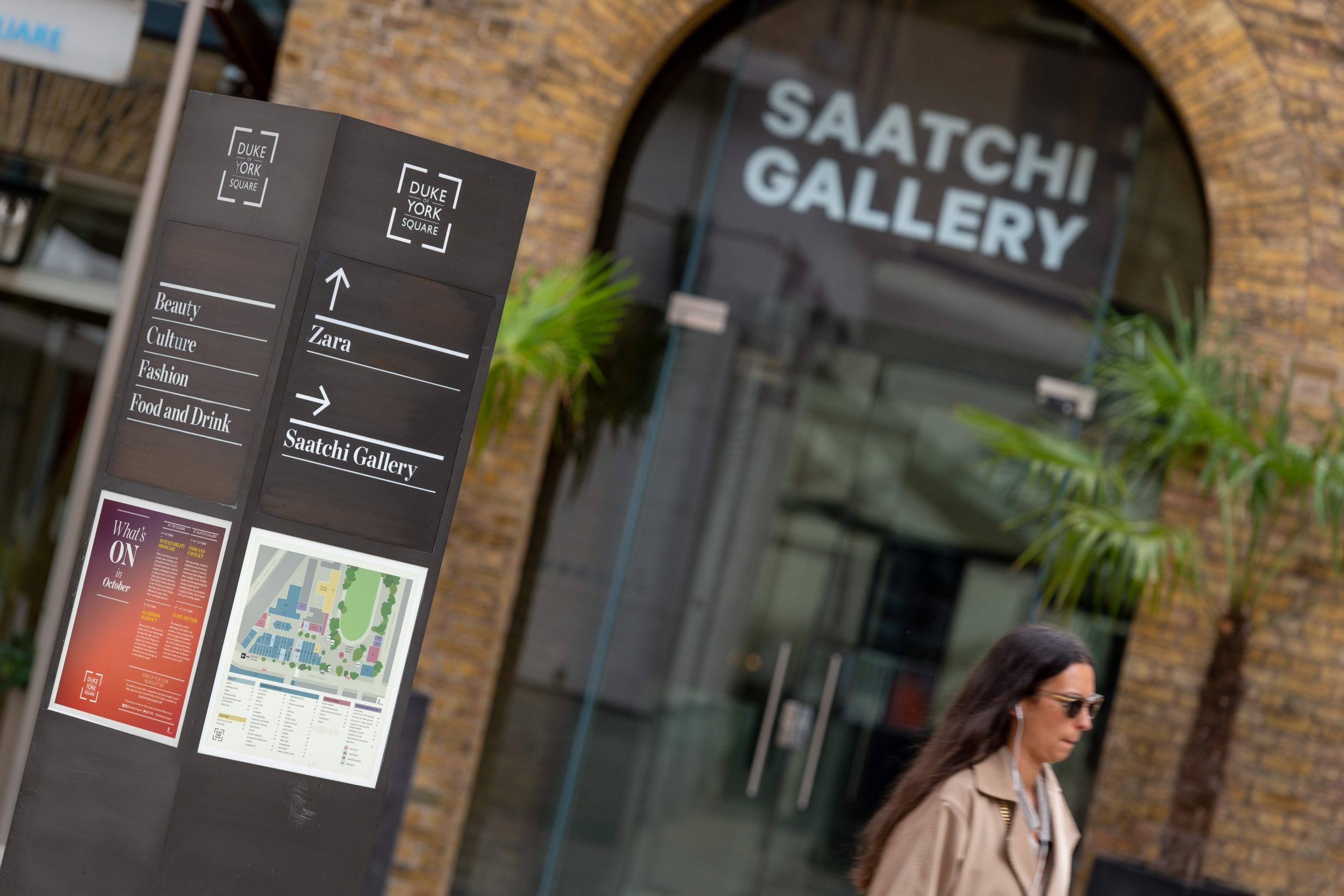 Close up of the entrance to Saatchi Gallery with a smartly dressed lady in front