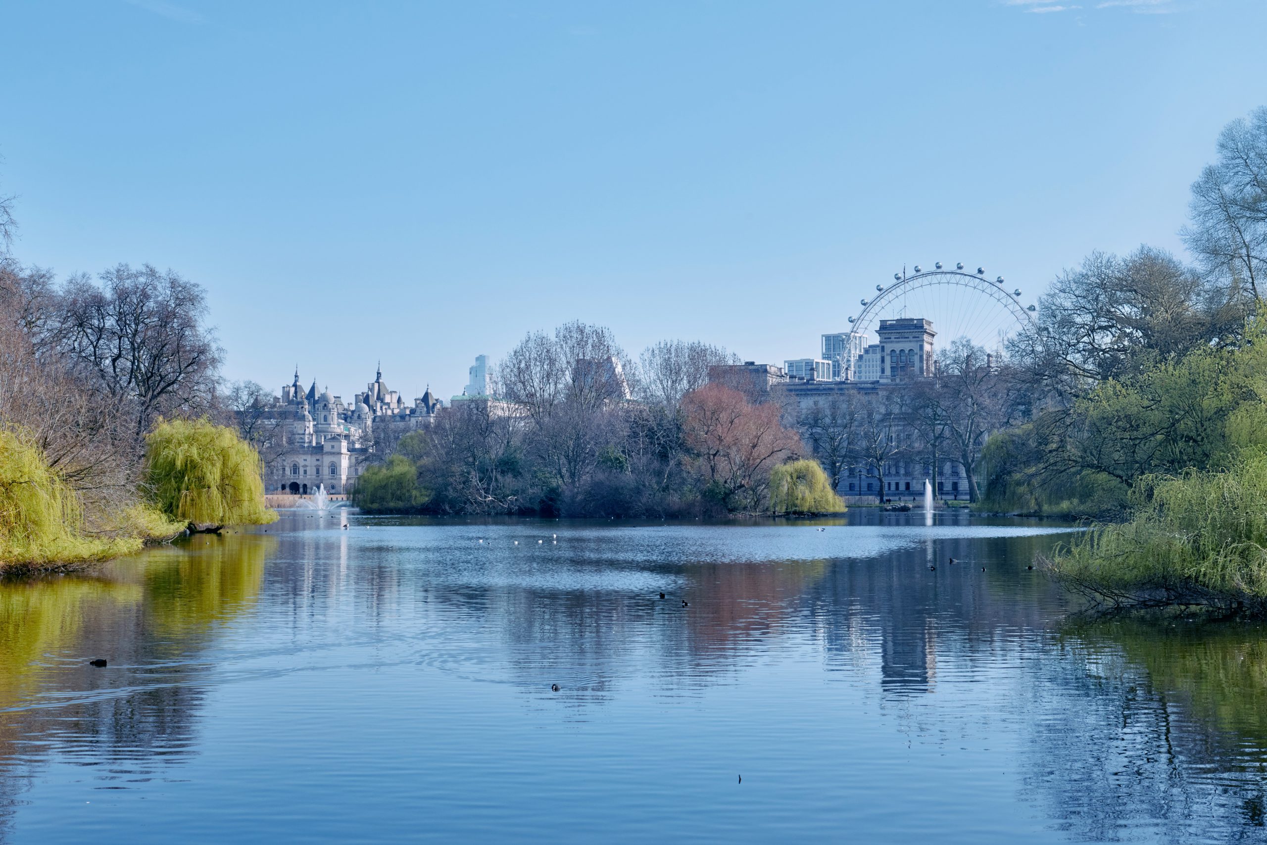View across the lake at St James' Park in the direction of Buckingham Palace with the London Eye in the distance