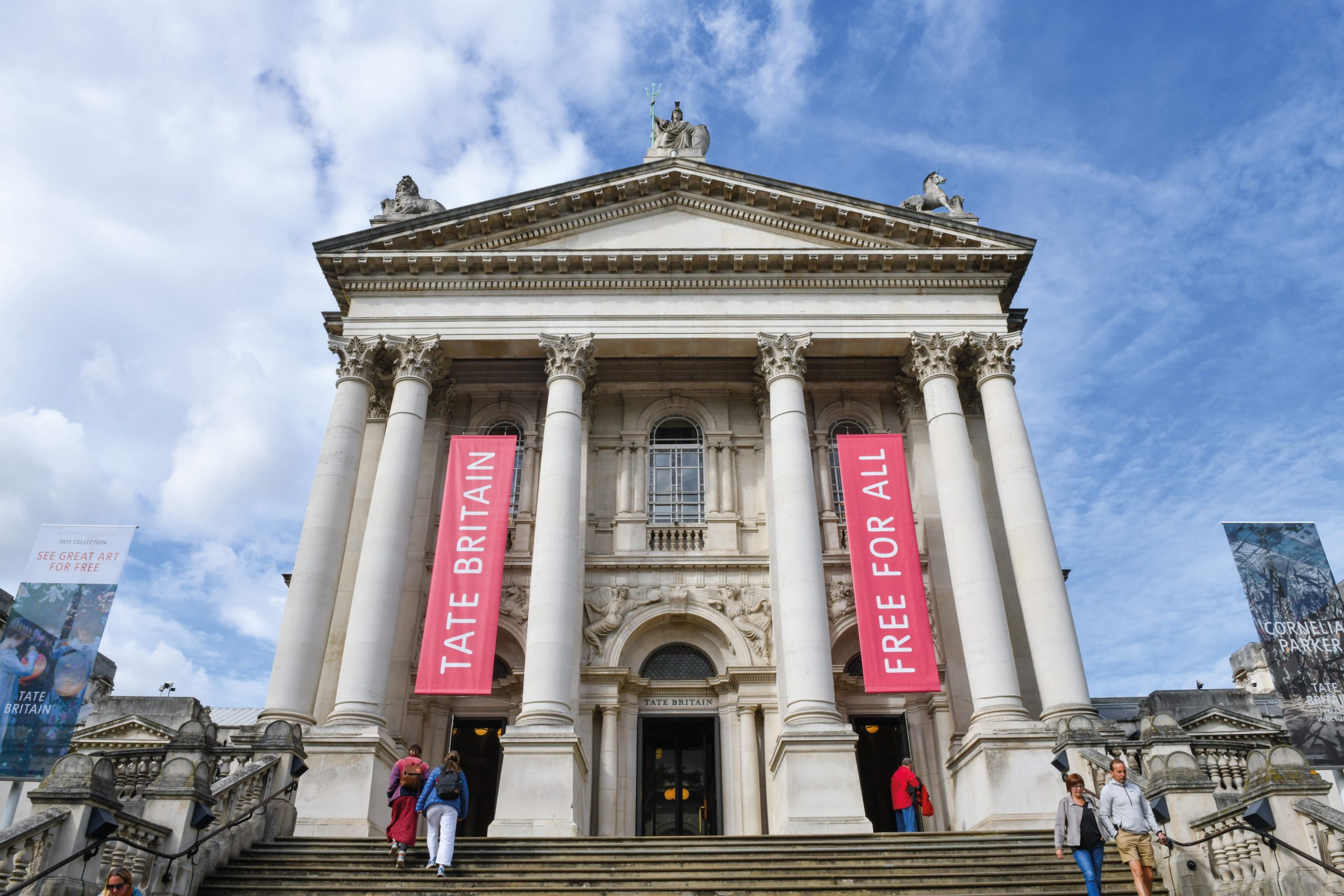 The grand entrance facade of Tate Britain in Pimlico against a bright blue sky