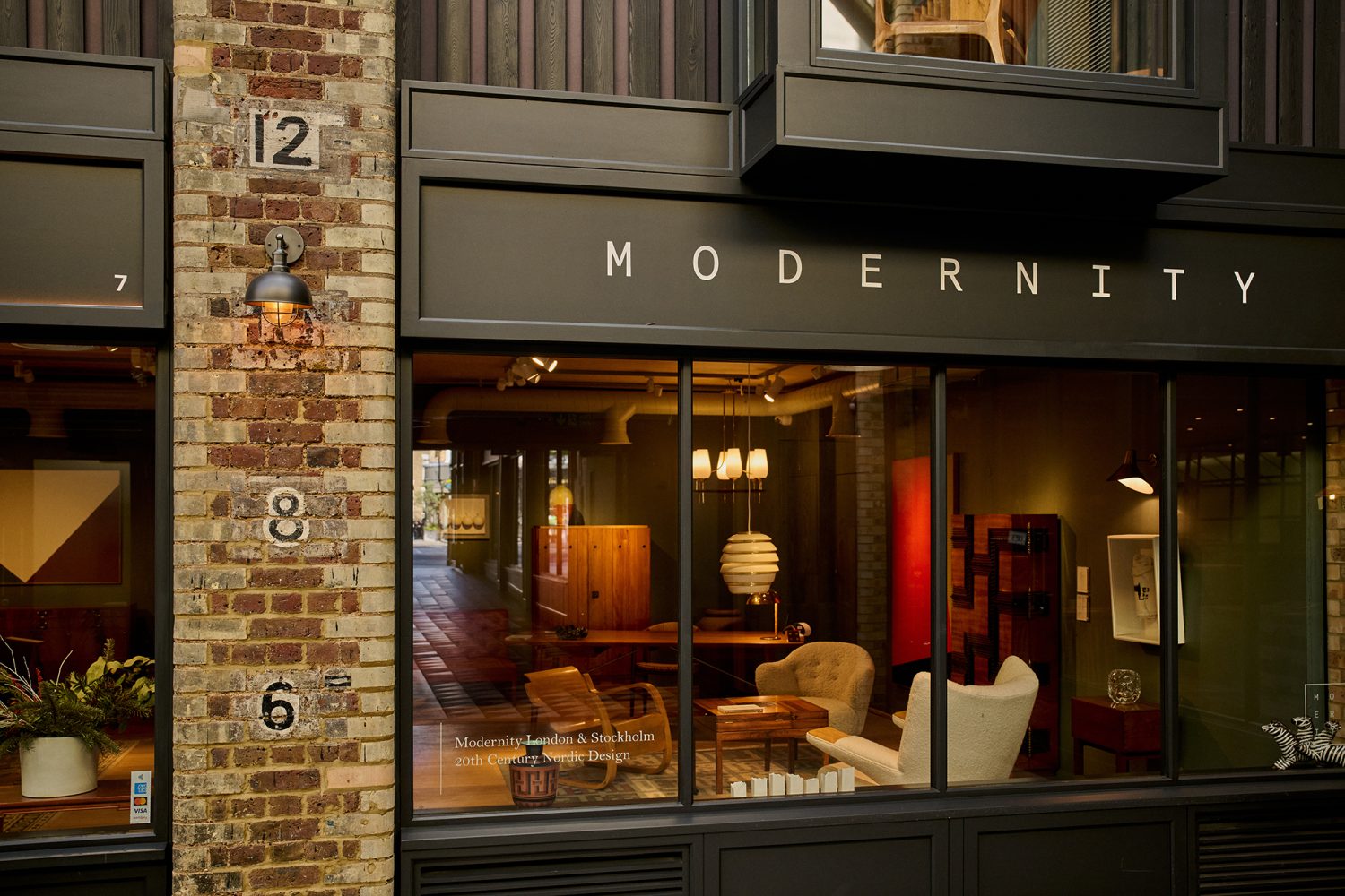 Close up view of the shop front at the Modernity interior design store at Newton's Yard with a collection of designer chairs on display