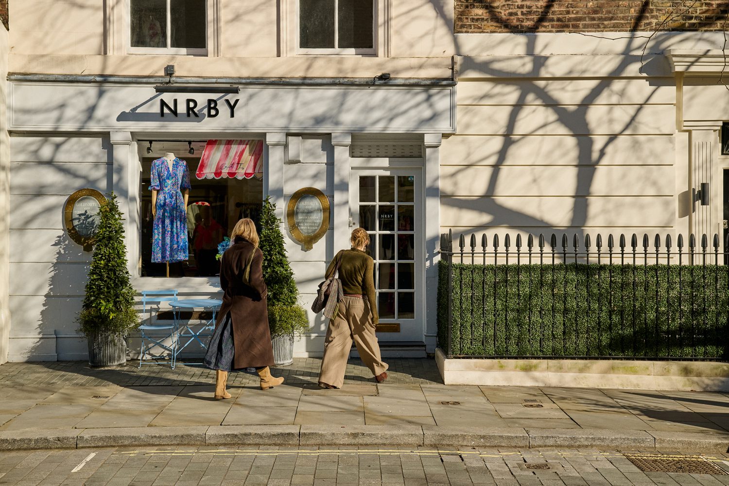 Two smartly dressed ladies walking into a boutique clothing store on King's Road