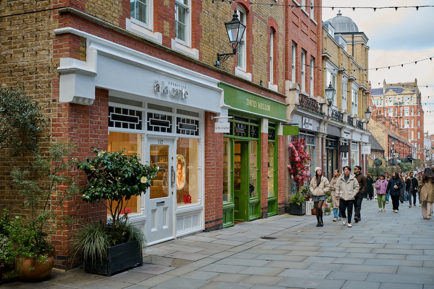 People shopping on pedestrianised street lined with boutique shops