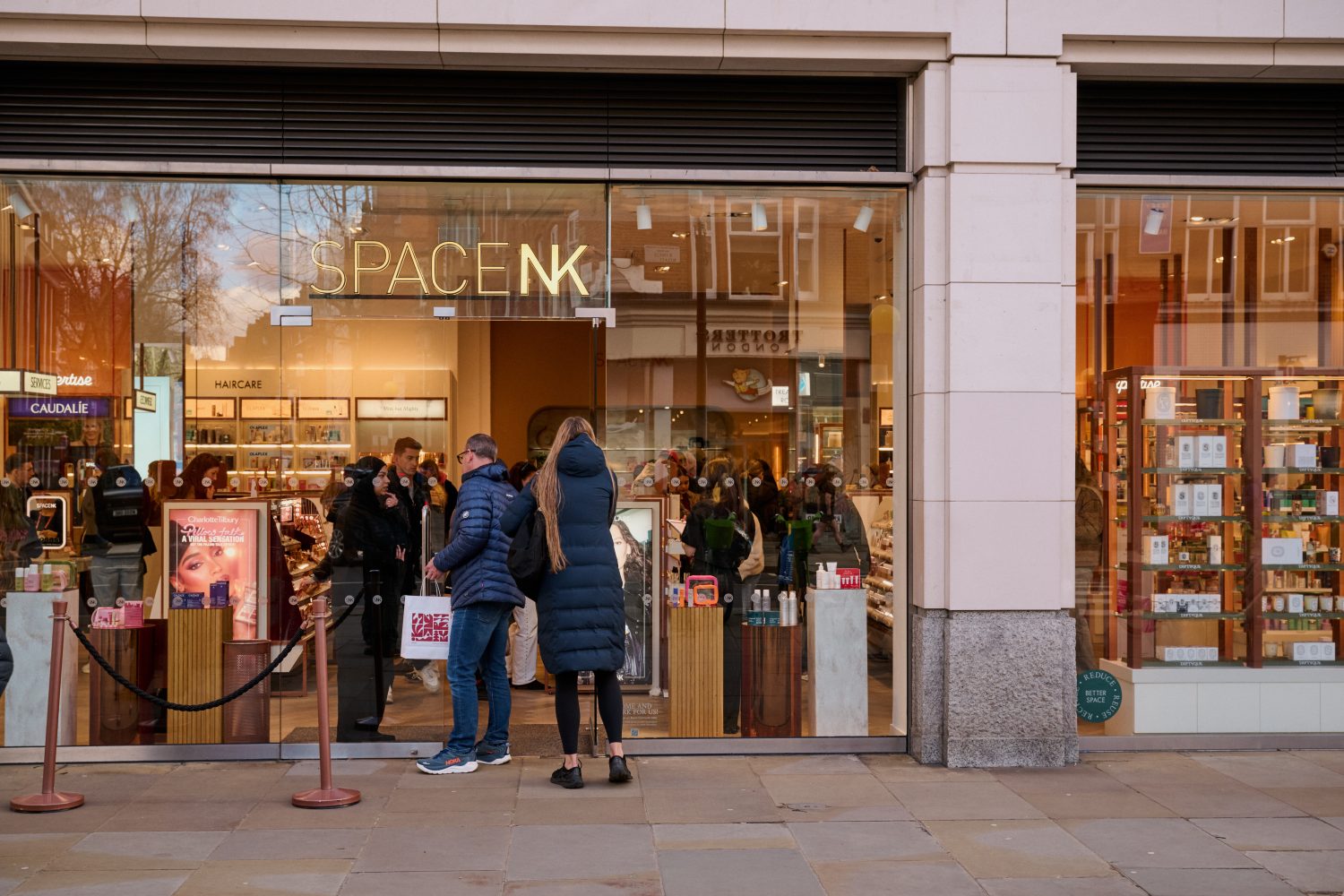 Exterior of SpaceNK beauty store with a queue of people outside waiting to go in