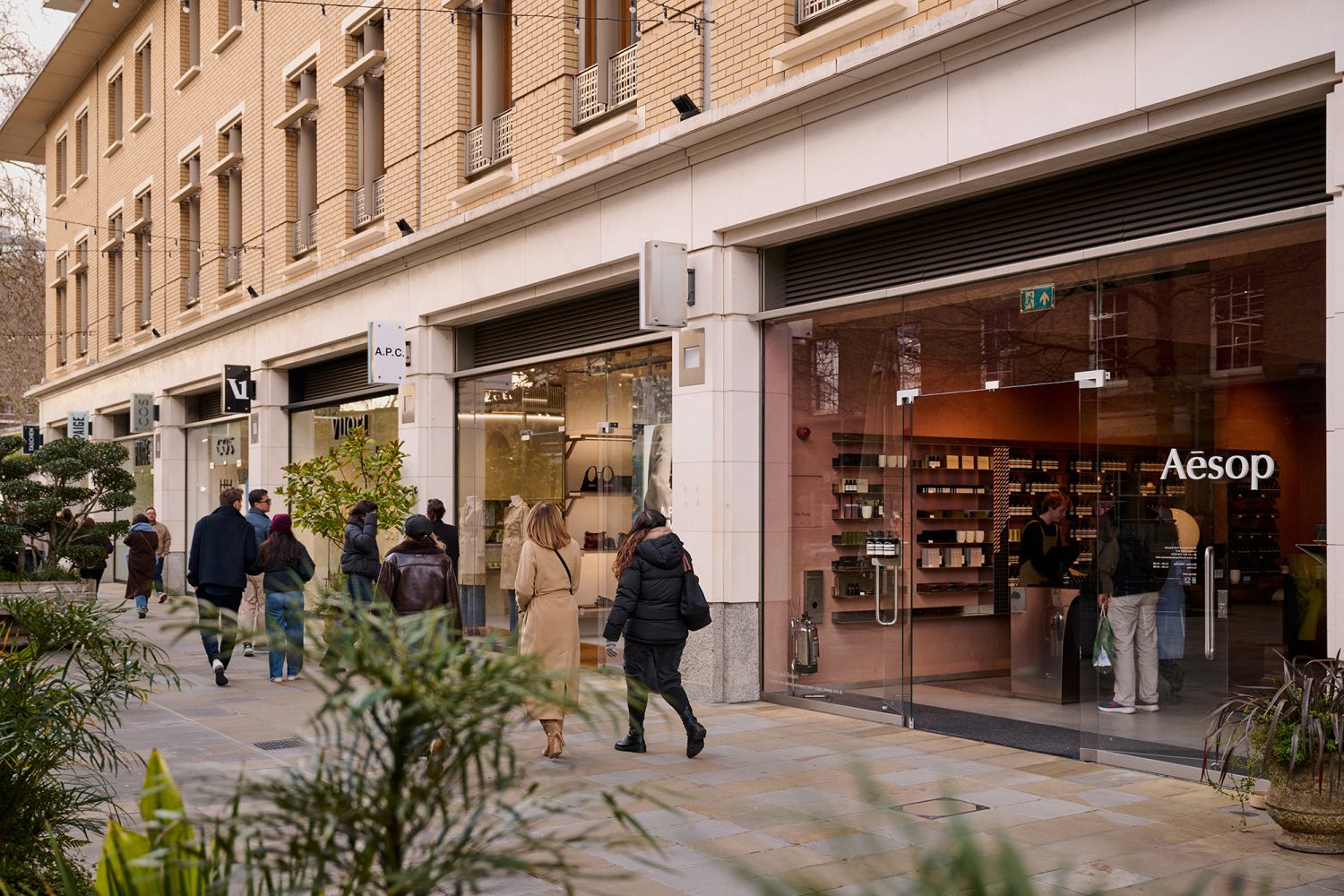 Shoppers walking past designer boutiques in Duke of York Square