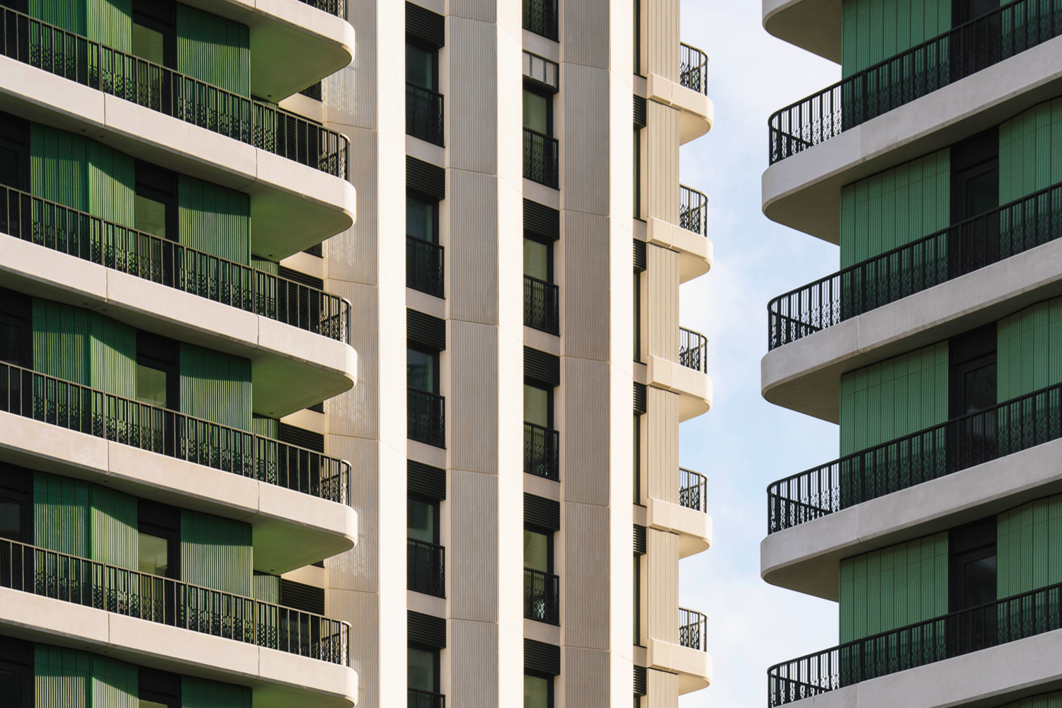 Close up view of Sutherland Apartments, showing distinctive curved balconies and distinctive green and stone facade